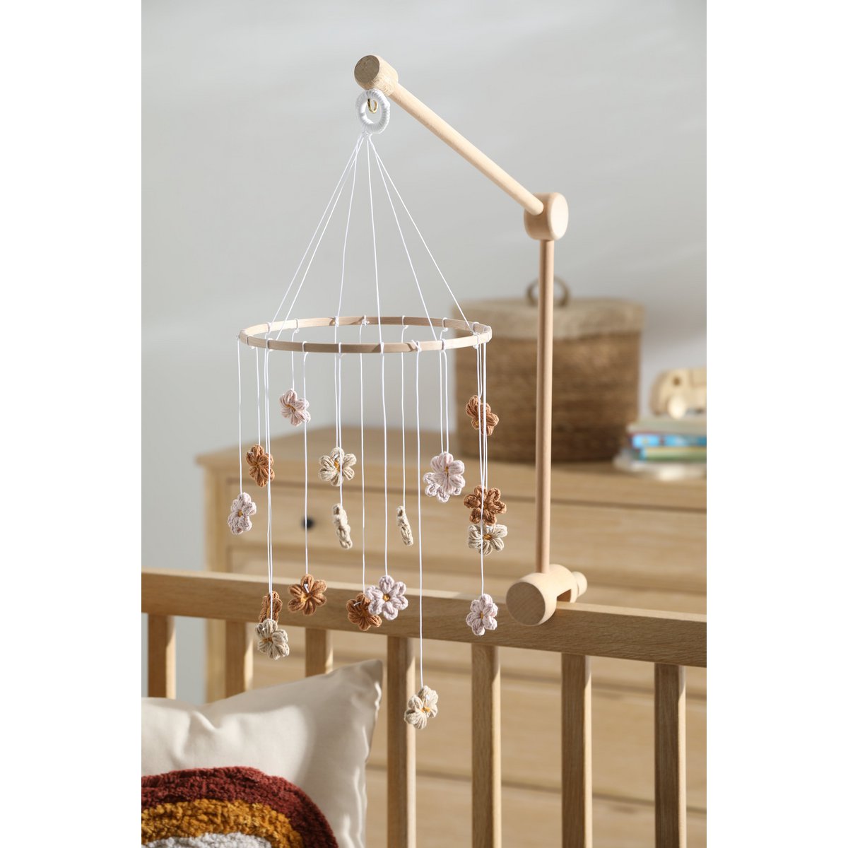 Sanftes Baby-Mobile HIMMELBLOM von 2 Stories aus Baumwolle und Holz – zarte Blüten in Beige und Rosa hängen an einem Holzring und drehen sich ruhig über dem Babybett. Die handgearbeiteten Blumen sorgen für eine beruhigende, natürliche Atmosphäre im Kinderzimmer.