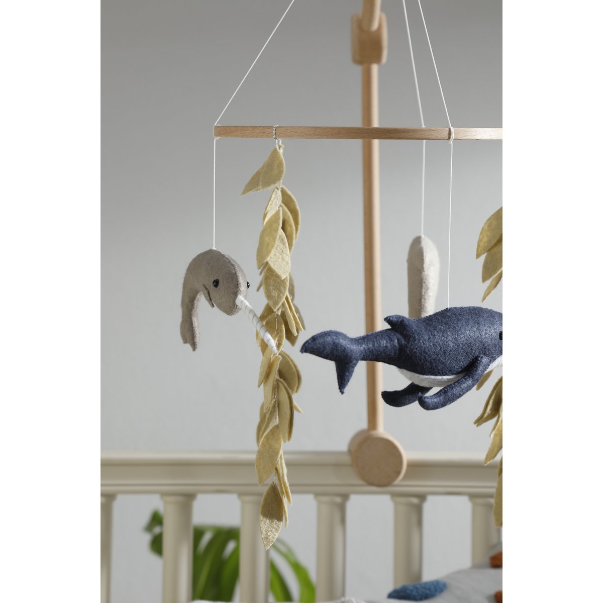 Rückansicht der Walflosse aus Filz, gefolgt von einem Schwertfisch – Teil des maritimen OCEAN Mobiles von 2 Stories, vor hellem Hintergrund