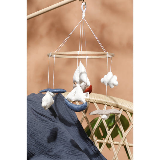 Handgefertigtes Baby-Mobile MARINA von 2 Stories aus Filz mit maritimen Motiven: drei Boote in Weiß, Blau und Rot, zwei Möwen und zwei Wolken in sanften Beige- und Blautönen – liebevoll gestaltet für das Babybett.