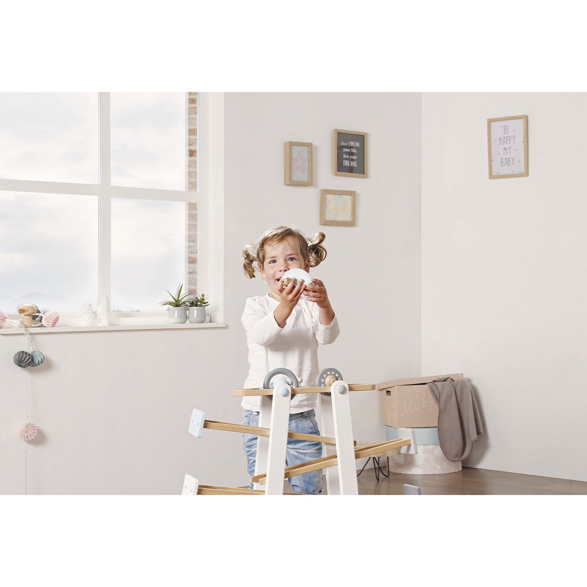 Kleinkind spielt mit Kugelbahn 'Kuno' aus Holz, mit bunten Bahnen und rollenden Kugeln, fördert Motorik und Koordination von Kleinkindern