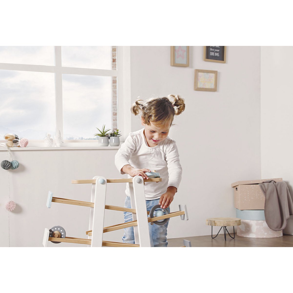 Kleinkind spielt mit Kugelbahn 'Kuno' aus Holz, mit bunten Bahnen und rollenden Kugeln, fördert Motorik und Koordination von Kleinkindern