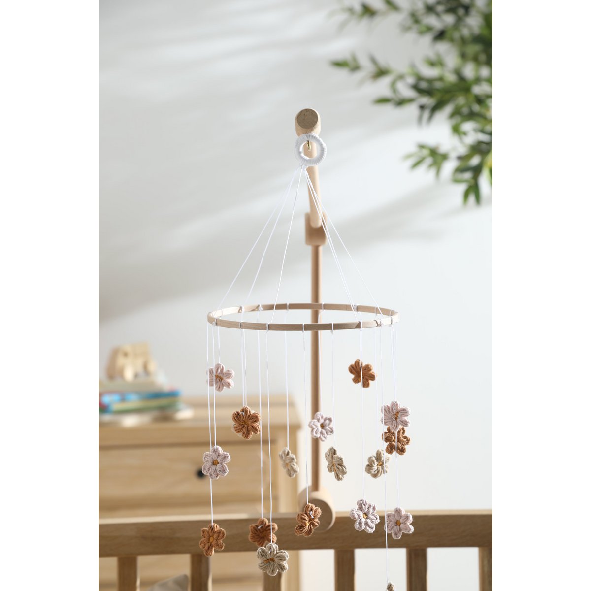 Sanftes Baby-Mobile HIMMELBLOM von 2 Stories aus Baumwolle und Holz – zarte Blüten in Beige und Rosa hängen an einem Holzring und drehen sich ruhig über dem Babybett. Die handgearbeiteten Blumen sorgen für eine beruhigende, natürliche Atmosphäre im Kinderzimmer.