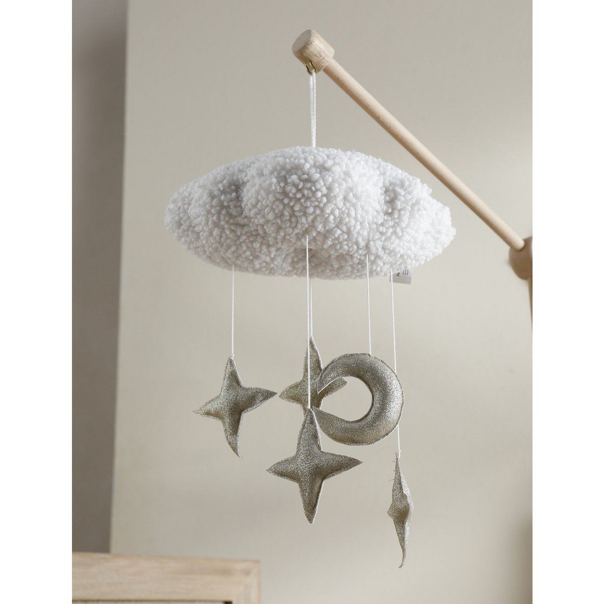 Handgefertigtes CIRRUS Mobile von 2 Stories aus Polyester in Gold, Bronze und Weiß – eine schlichte weiße Wolke schwebt über mehreren glitzernden Sternen. Das Mobile sorgt über dem Babybett für eine traumhafte Atmosphäre.