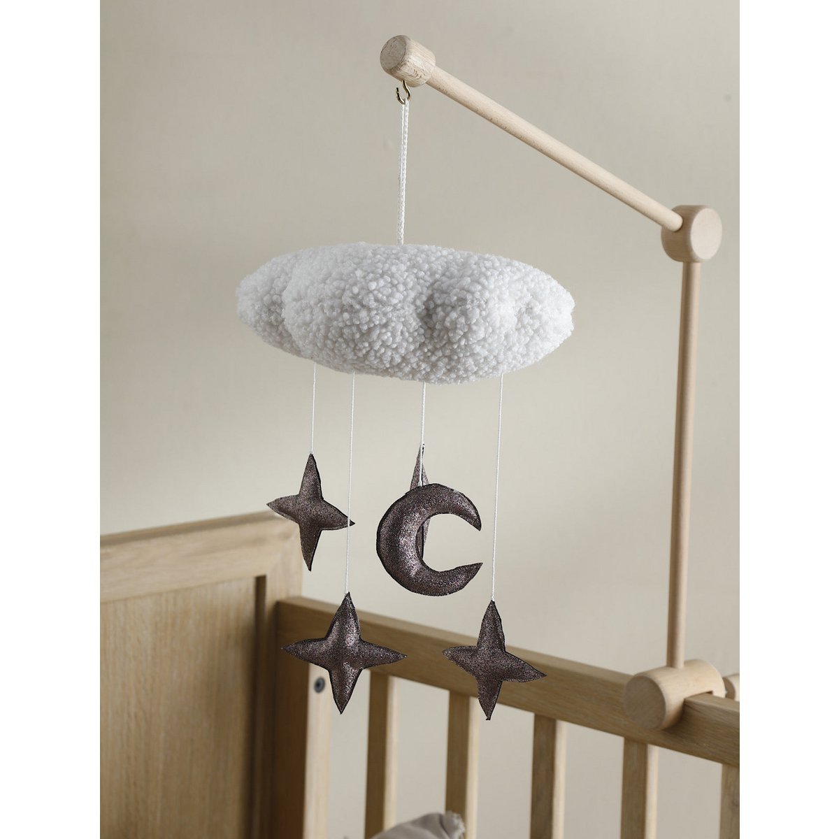 Handgefertigtes CIRRUS Mobile von 2 Stories aus Polyester in Gold, Bronze und Weiß – eine schlichte weiße Wolke schwebt über mehreren glitzernden Sternen. Das Mobile sorgt über dem Babybett für eine traumhafte Atmosphäre.