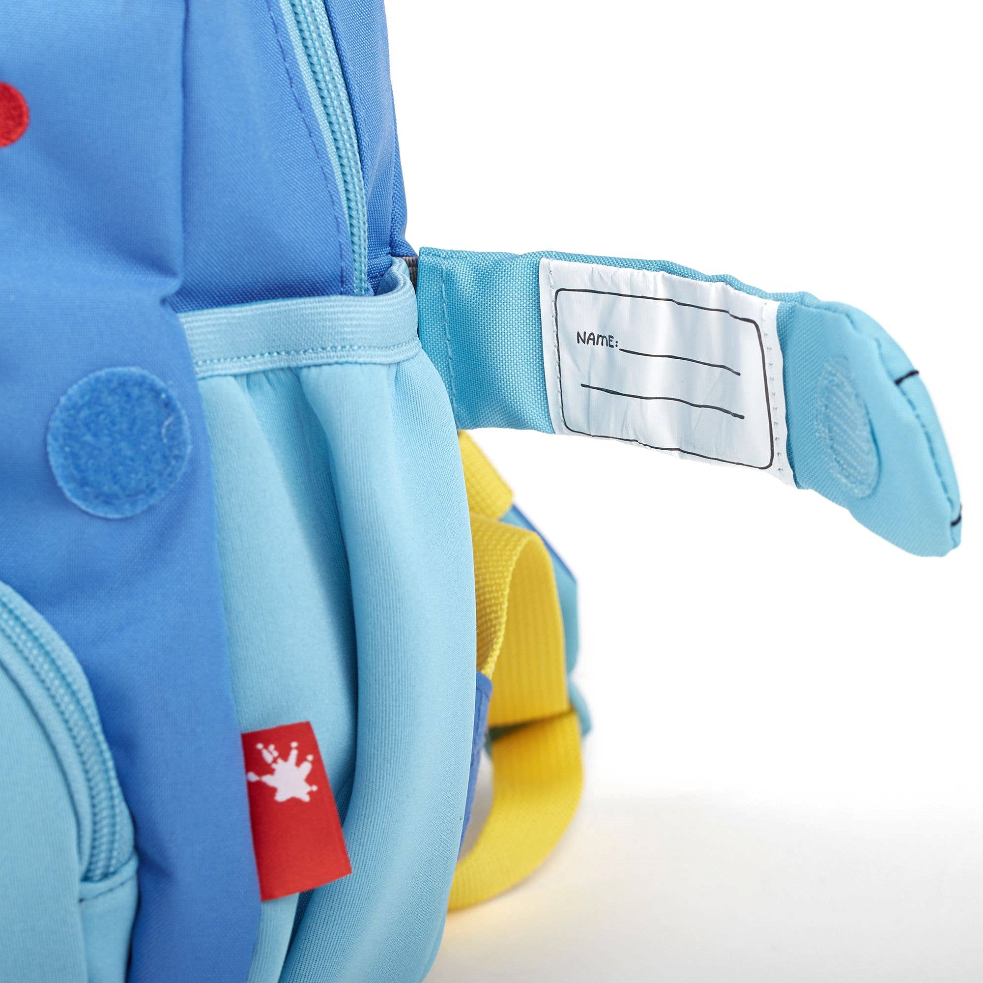 Integriertes Namenschild mit Klettverschluss hinter dem Bärenpfötchen am Kinderrucksack Bär von Sigikid, blau mit plüschigen Bärenohren und geräumigem Hauptfach, ideal für Kinder