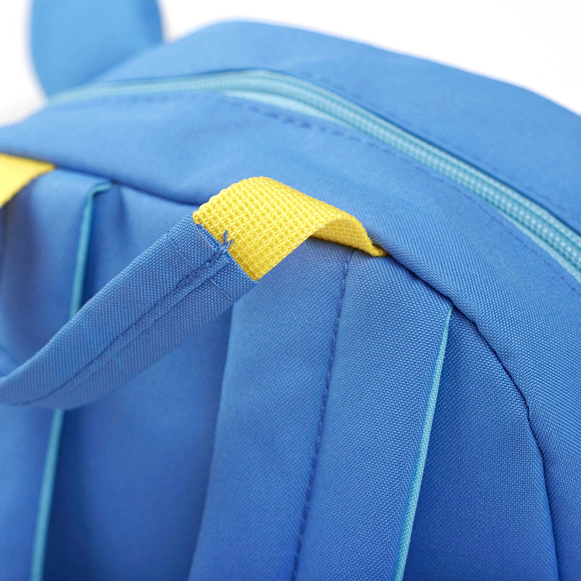 Gelb abgesetzter, verstärkter Trageriemen des Kinderrucksack Bär von Sigikid, blau mit plüschigen Bärenohren und geräumigem Hauptfach, ideal für Kinder