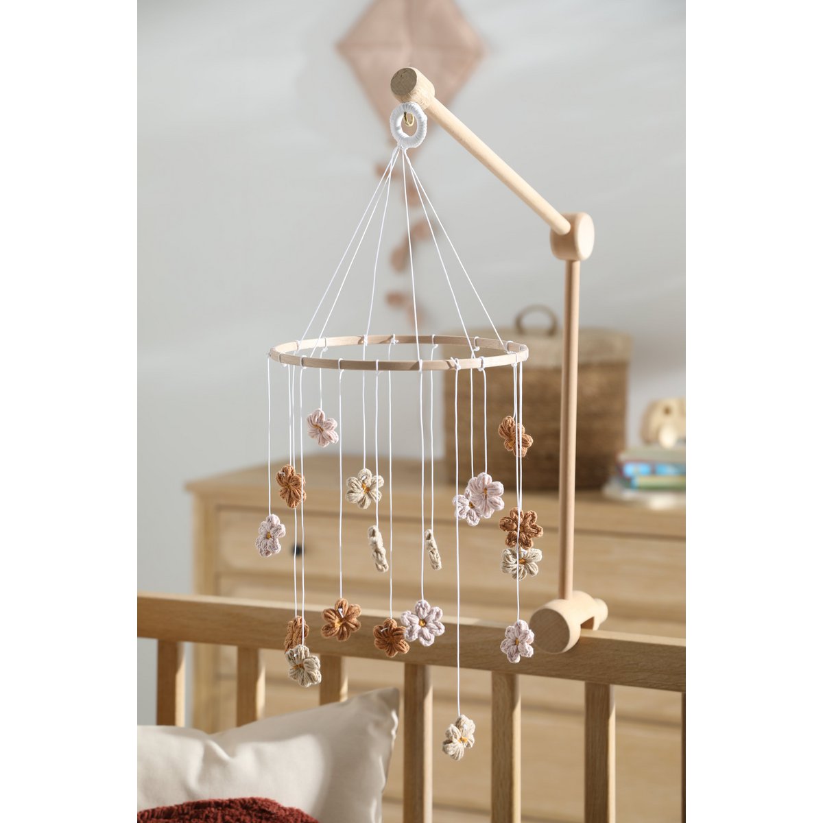 Sanftes Baby-Mobile HIMMELBLOM von 2 Stories aus Baumwolle und Holz – zarte Blüten in Beige und Rosa hängen an einem Holzring und drehen sich ruhig über dem Babybett. Die handgearbeiteten Blumen sorgen für eine beruhigende, natürliche Atmosphäre im Kinderzimmer.