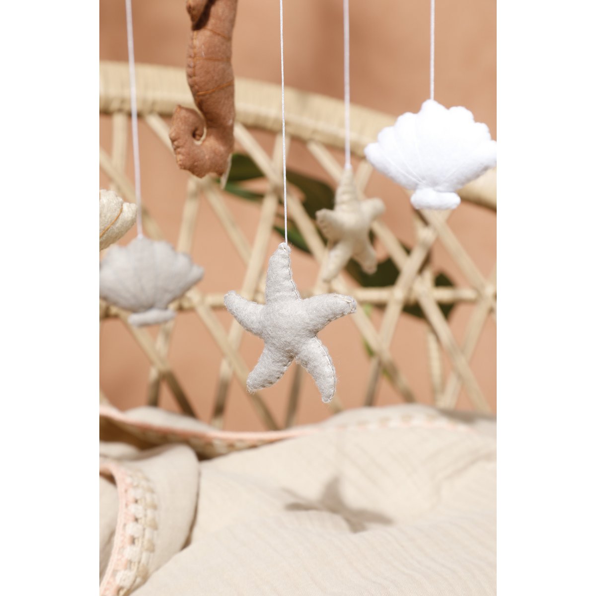 Nahaufnahme eines beigefarbenen Filzsterns aus dem SEA Mobile von 2 Stories – liebevoll handgearbeitet, mit sichtbarer Wollstruktur.