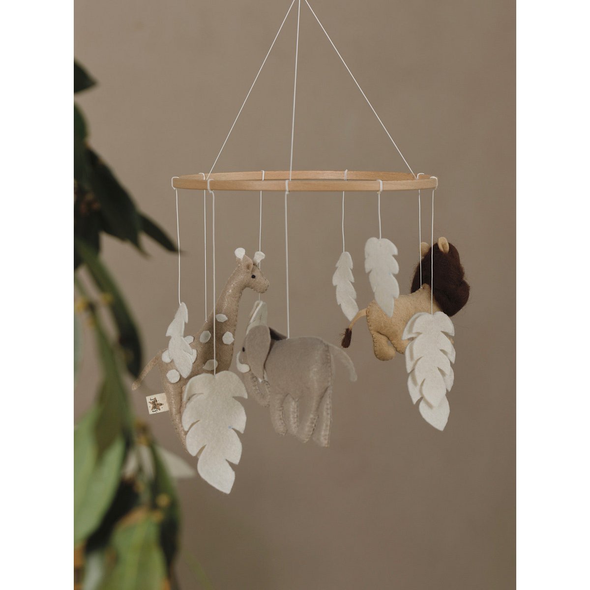 Handgefertigtes SAFARI Mobile von 2 Stories aus Filz, Polyester und Holz – mit Safari-Tieren wie Löwe, Elefant und Giraffe in Beige, Braun, Grau und Weiß, liebevoll gestaltet für das Babybett