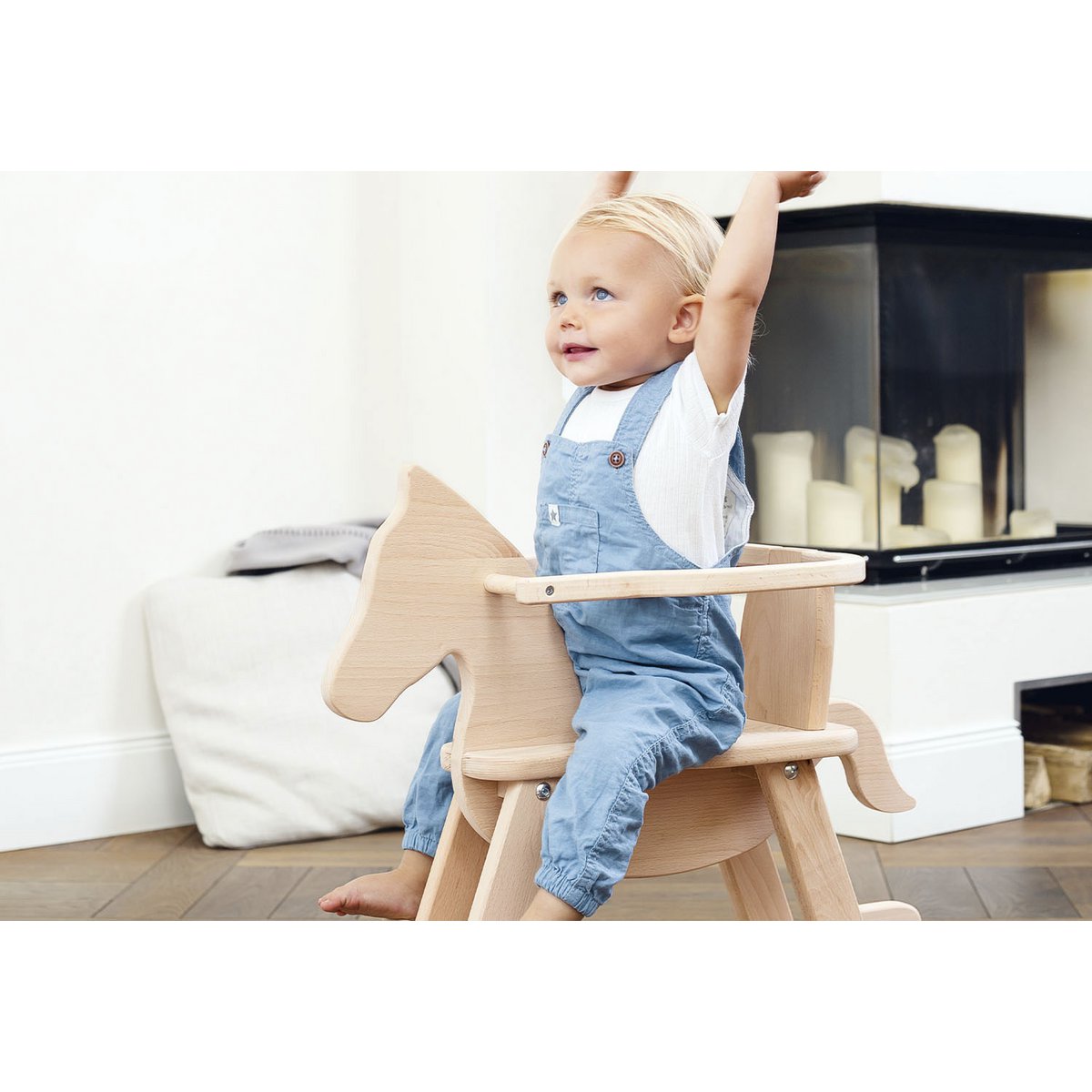Kind schaukelt freihändig auf dem Schaukelpferd 'Pinolino' aus Holz mit Sicherheitsring, naturfarben, ideal für kleine Kinder ab 1 Jahr.