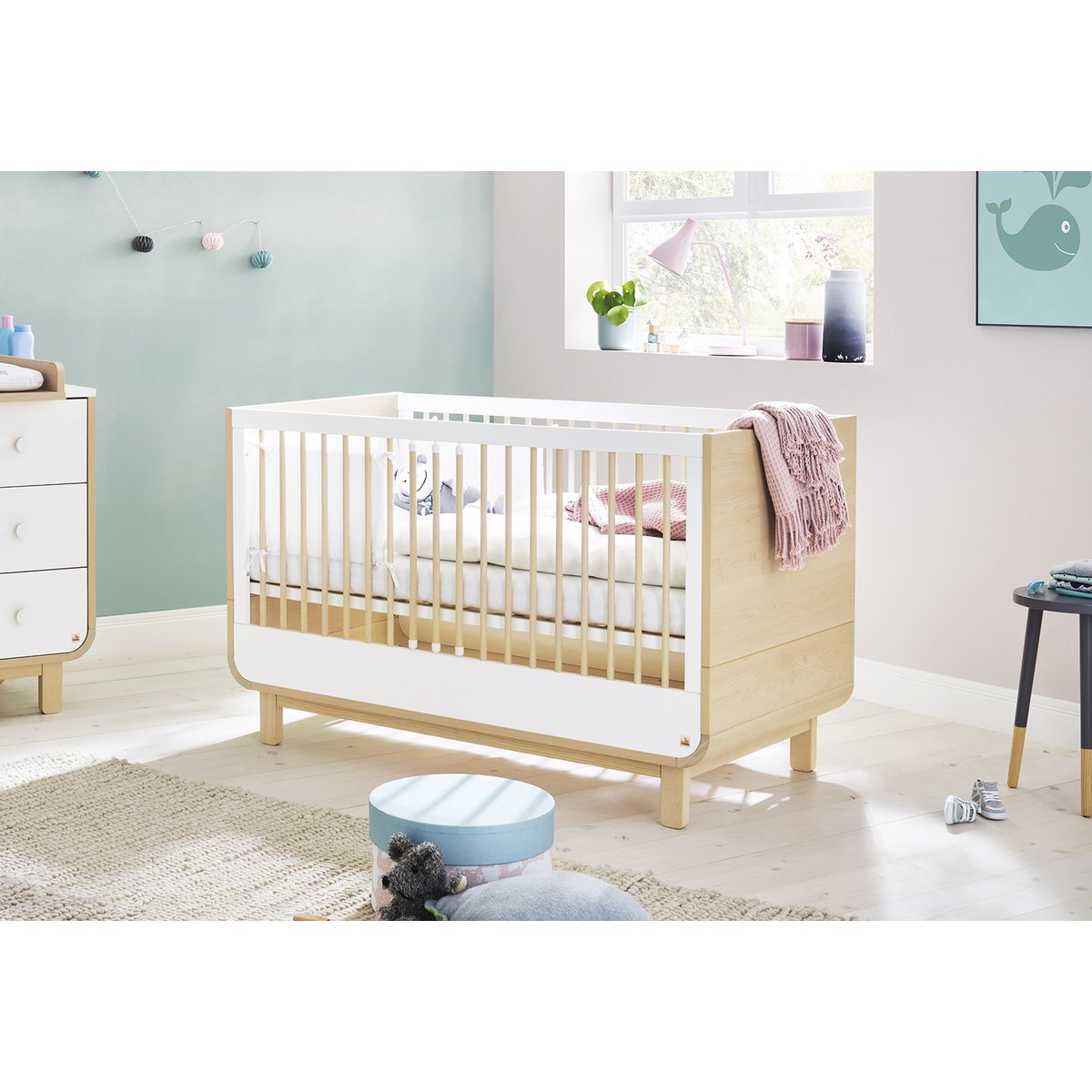 Mitwachsendes Kinderbett von Pinolino aus massivem Kiefernholz in Ahornoptik, aufgebaut in einem liebevoll eingerichteten Kinderzimmer mit weichen Farben, Deko und Spielzeug – ideal für Babys und Kleinkinder.