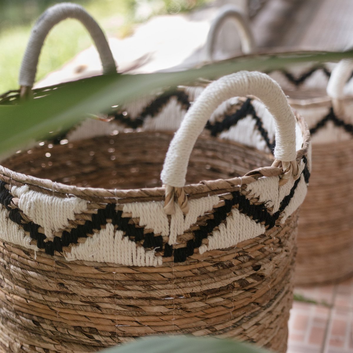 Nahaufnahme des Korbes  DALU aus natürlicher Bananenfaser, handgeflochten im Boho-Stil, vielseitig einsetzbar als Wäschekorb, Aufbewahrung oder Pflanzkorb – erhältlich in drei Größen mit attraktivem zickzack Muster am oberen Rand .