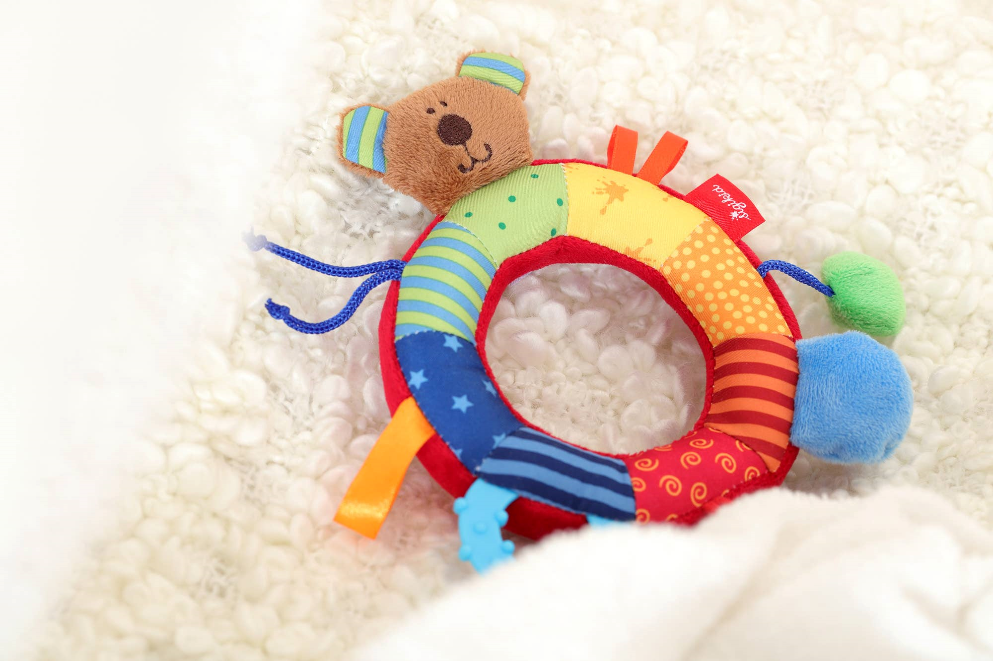 Babygreifling Bär, aus buntem Stoff, mit Rassel und Greifring, ideal für kleine Kinderhände. weich und zart