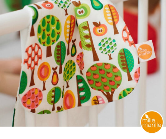 Retro-Bäume. Das nierenförmige Spucktuch von millemarille – endlich eine stilvolle Alternative zu den ausgewaschenen Moltonwindeln und ein garantierter Blickfang! Die bunten Bäume in den Farben rot, orange, grün und braun wecken Babys Neugier